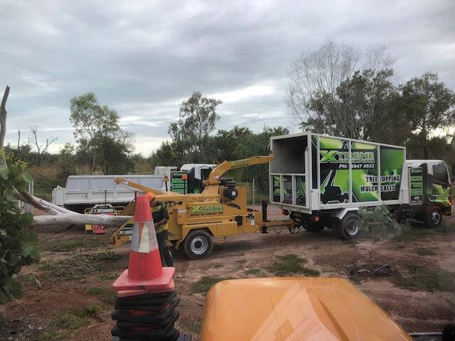 Chipper truck and traffic cones on a cleared rural Darwin property during tree works